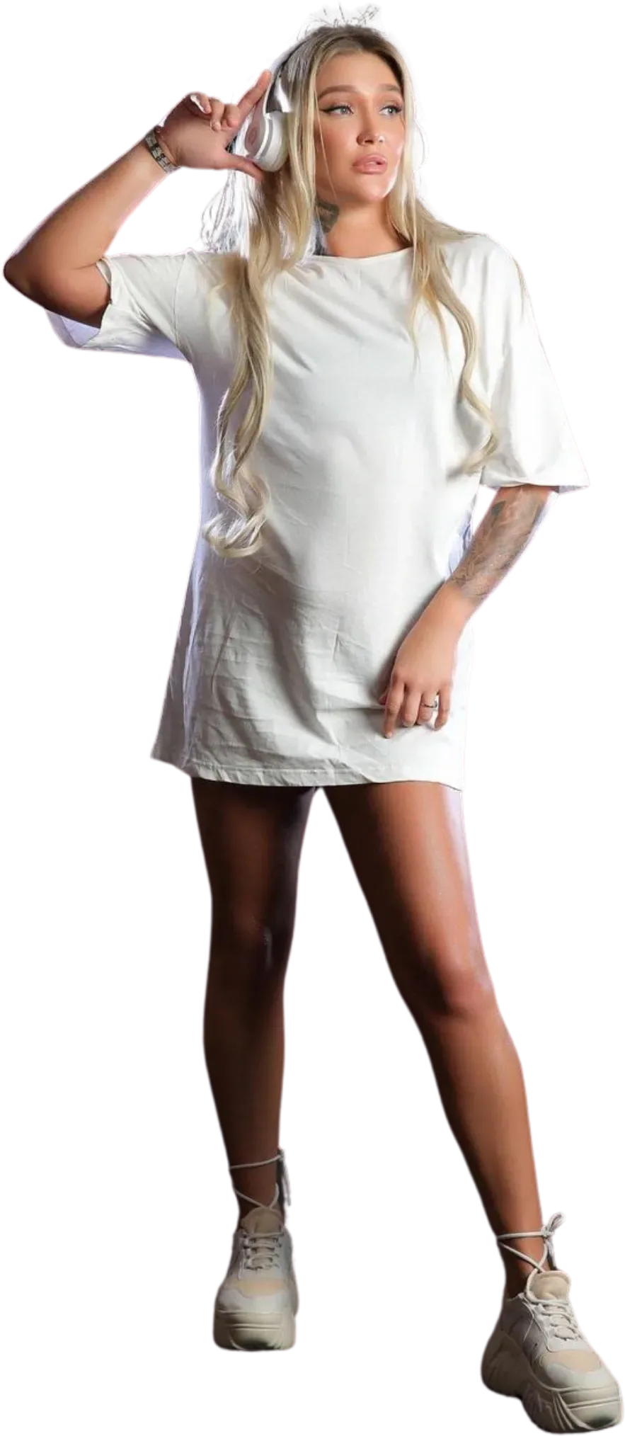 Zanna holding her studio headphones with a playful pose in a full-length studio shot
